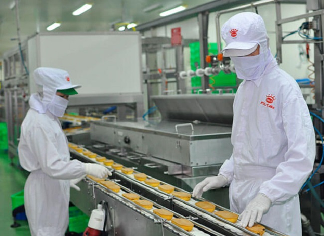 Công nhân đang thao tác trên dây chuyền sản xuất bánh hiện đại của Kinh Đô Miền Bắc