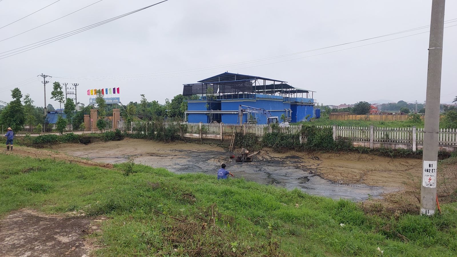 Hồ chứa bùn thải đang được công nhân bơm hút xả trực tiếp ra môi trường của Nhà máy nước Quang Châu
