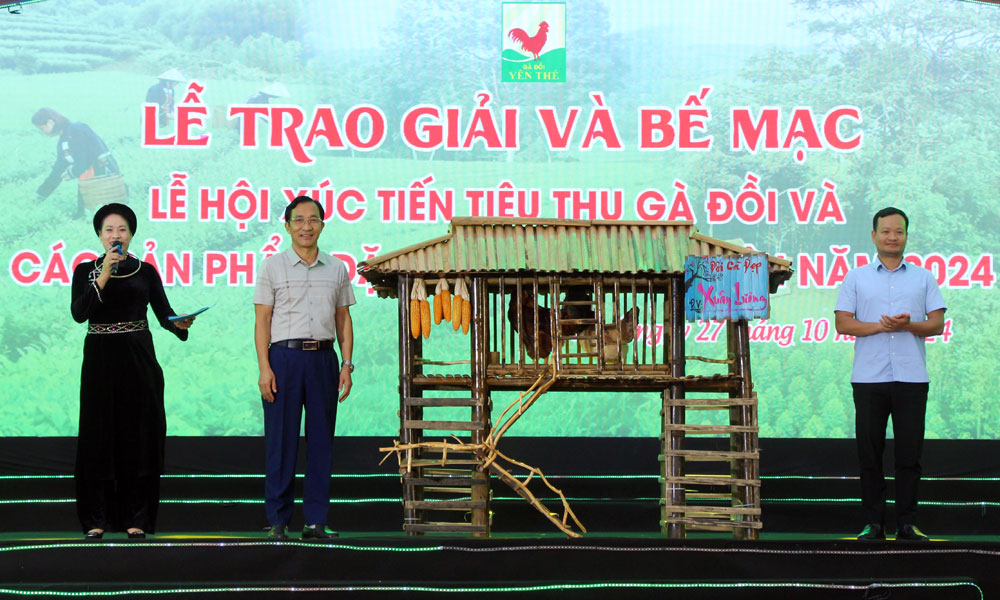 Đồng chí Thân Hải Nam, Chủ tịch UBND huyện Yên Thế trao đôi gà đẹp cho khách hàng trúng đấu giá.