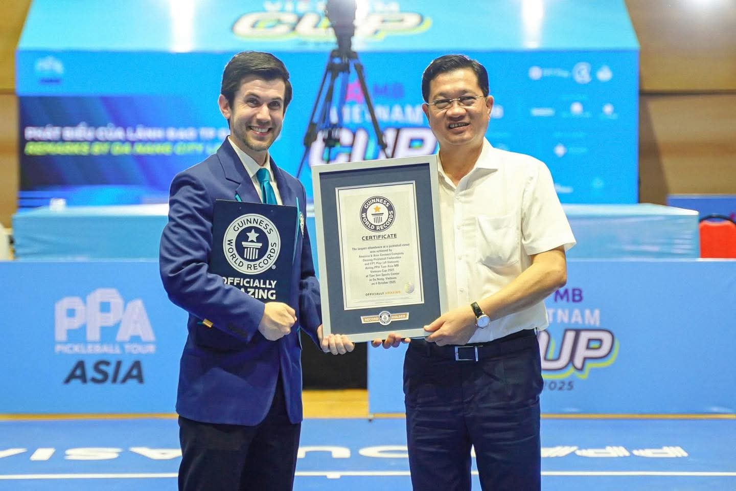 Phó Chủ tịch Thường trực HĐND thành phố, Chủ tịch Liên đoàn Pickleball thành phố Đà Nẵng Trần Phước Sơn (bên phải) đón nhận chứng nhận kỷ lục từ đại diện Guinness World Records về giải Pickleball có lượng khán giả trực tiếp đông nhất thế giới
