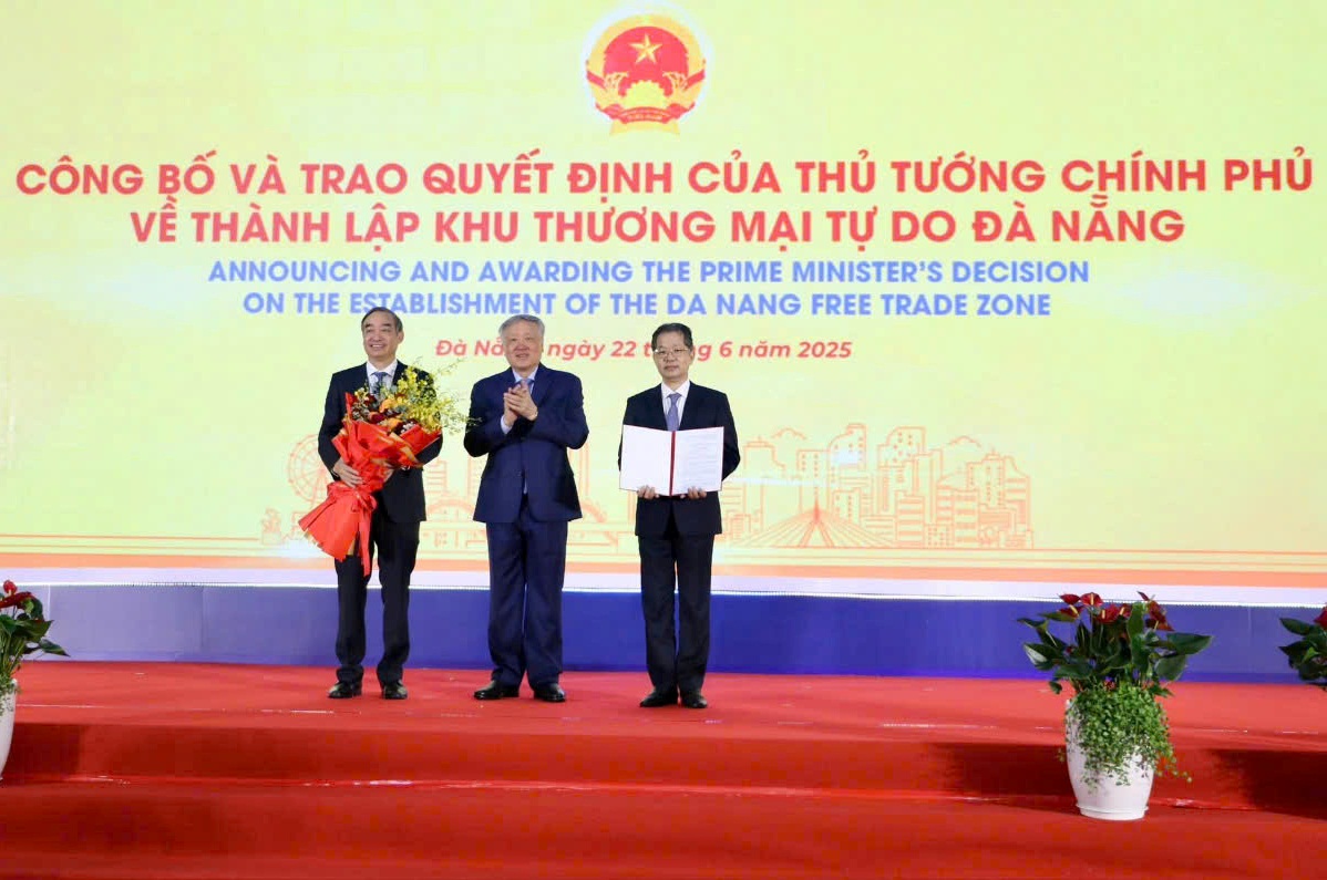 Phó Thủ tướng Thường trực Chính phủ Nguyễn Hòa Bình (giữa) trao Quyết định của Thủ tướng Chính về việc thành lập Khu thương mại tự do Đà Nẵng cho lãnh đạo thành phố Đà Nẵng - dấu mốc quan trọng trong chiến lược phát triển thương mại - dịch vụ