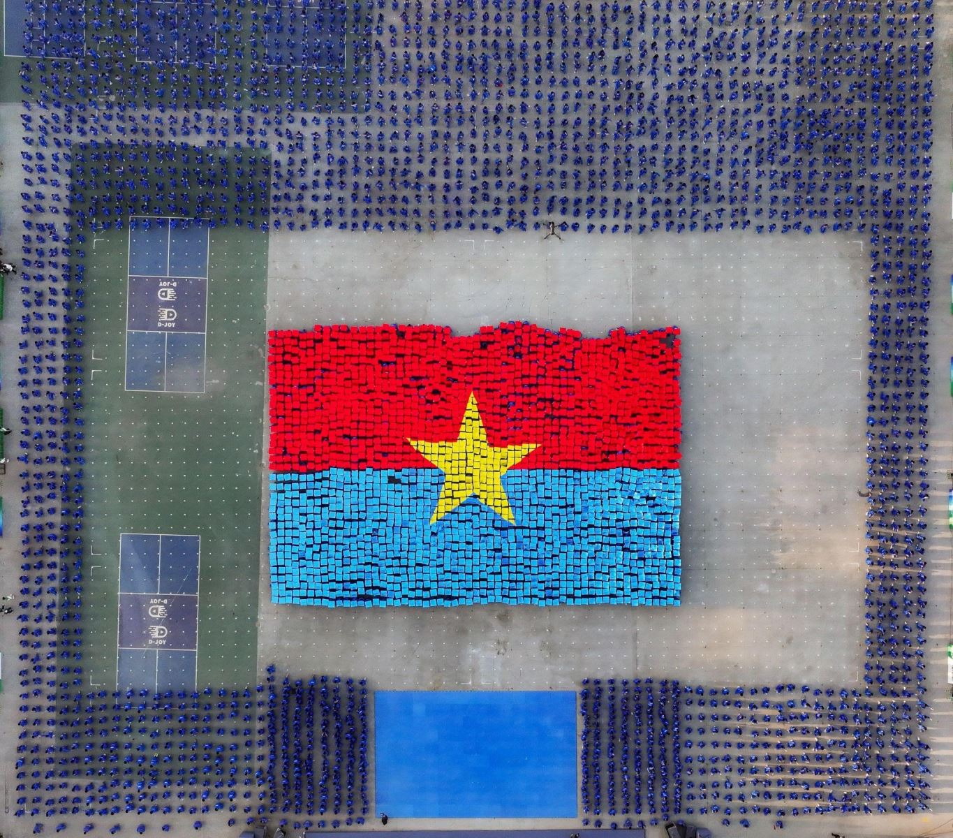 Học sinh xếp hình lá cờ của Mặt trận Dân tộc Giải phóng miền Nam Việt Nam, biểu tượng tinh thần đoàn kết và lịch sử.