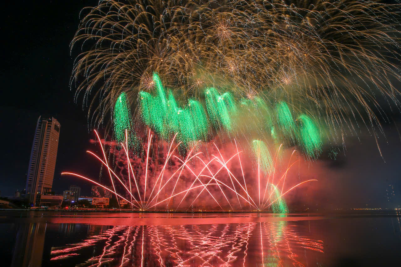 Cả bầu trời như bừng sáng với những dải pháo hoa sáng màu xanh lục, tím lam, và hồng rực, loé lên như cực quang, hiện tượng thiên nhiên kỳ ảo của xứ Bắc Âu