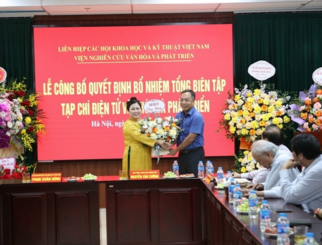 Tổng Biên tập Báo Đầu tư Lê Trọng Minh tặng hoa chúc mừng tân Tổng Biên tập Tạp chí Văn hóa và Phát triển Nguyễn Thị Hoa. 