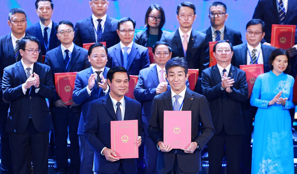 Thủ tướng Phạm Minh Chính chứng kiến lãnh đạo tỉnh Bắc Ninh trao Quyết định chủ trương đầu tư, giấy chứng nhận đăng ký đầu tư, biên bản ghi nhớ cho các nhà đầu tư./Ảnh báo Nhân Dân