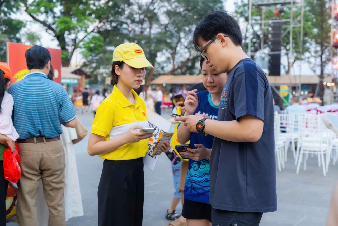 Khách tham quan được hướng dẫn thông tin về bản đồ ẩm thực trực tuyến thuộc đề án “Biến Tấu Vạn Nguyên Liệu, Nấu Triệu Món Việt”