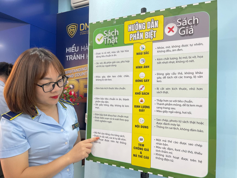 Cán bộ QLTT thông tin về các dấu hiệu nhận biết sách giả-sách thật.