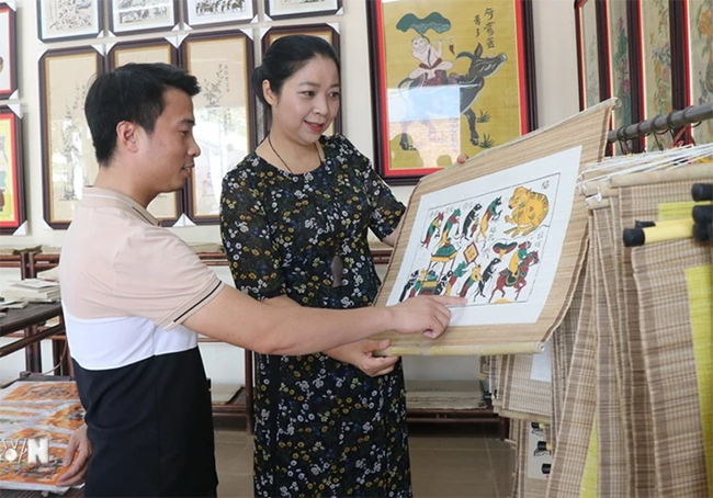 Du khách tham quan, tìm hiểu tranh dân gian Đông Hồ tại khu trưng bày. Ảnh: T.Hùng