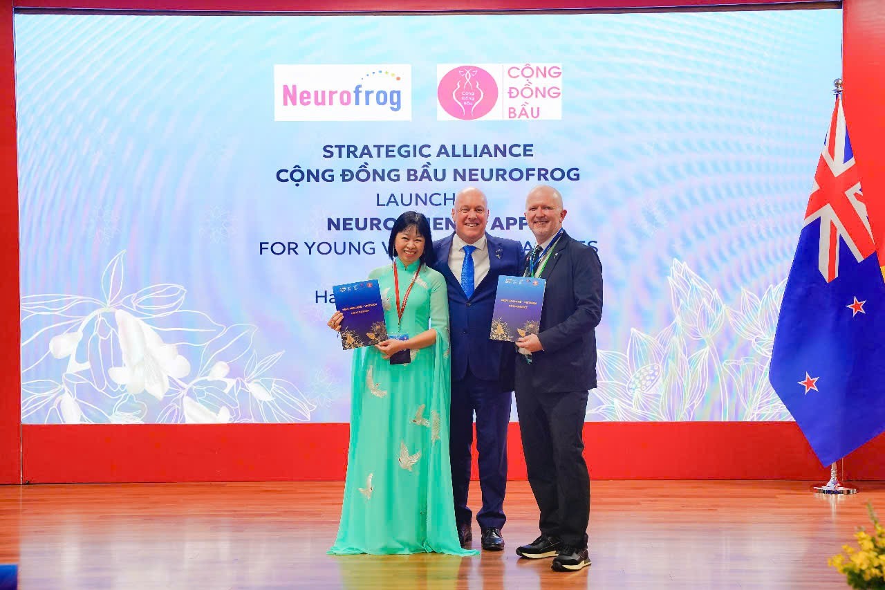 Thủ tướng New Zealand Christopher Luxon (ở giữa) chứng kiến đại diện lãnh đạo Cộng Đồng Bầu và Neurofrog trao đổi Biên bản hợp tác. 