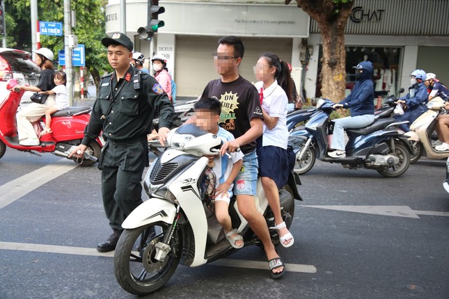 Phụ huynh học sinh chở con không đội mũ bảo hiểm bị các lực lượng chức năng tiến hành xử lý 