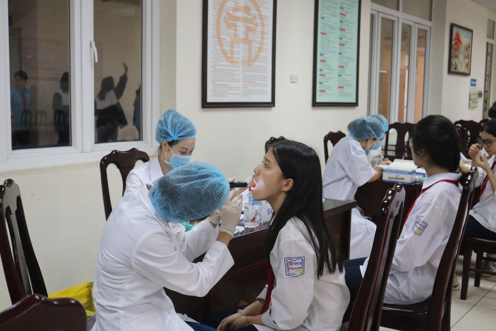 (Bác sĩ tại Nha khoa Smart thực hiện thăm khám răng miệng cho các em học sinh)