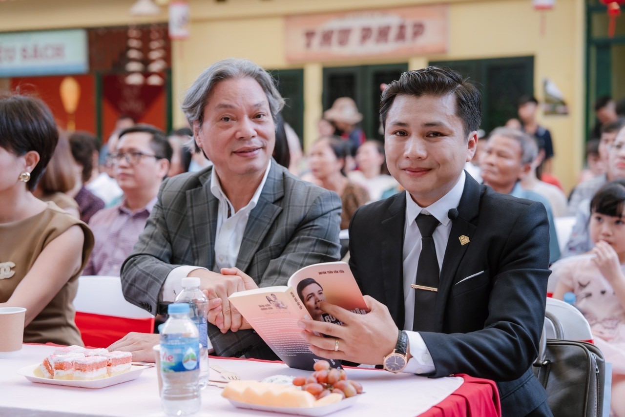 Tác giả Trần Văn Tiên (bên phải) cùng Giảng viên Học viện Hành chính Quốc gia Nguyễn Tất Thịnh tại buổi lễ ra mắt cuốn sách “Bước chân nhiệm màu”